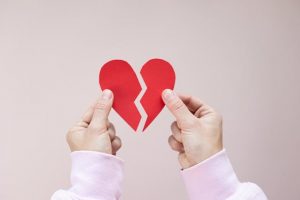 mains tenant deux parties d'un coeur brisé