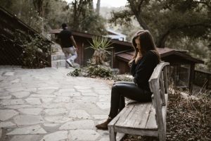 femme qui pleure seule sur un banc pendant qu'un homme part