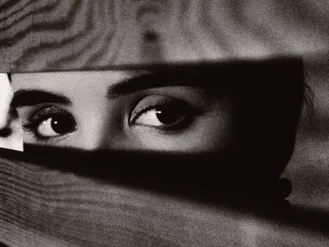 femme regardant a travers des barreaux en bois
