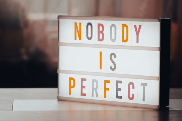 lettres sur un tableau écran avec écrit : nobody is perfect